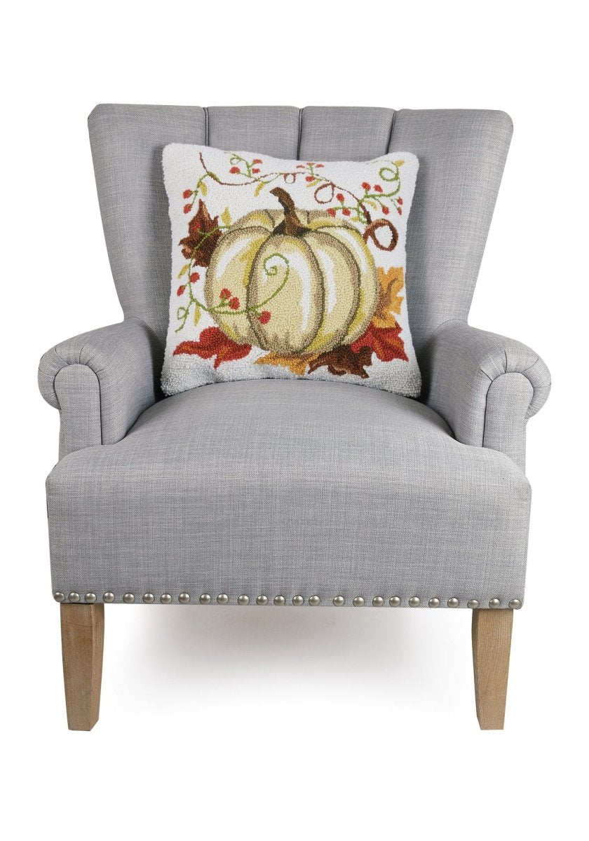 Cream Harvest Pumpkin Hooked Wool Fall Harvest Throw Pillow on an armchair, showing the throw pillow at room scale, 18x18 inch