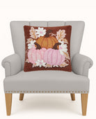 Daisies and Pumpkin Trio Hooked Wool Fall Harvest Throw Pillow on an armchair, showing the throw pillow at room scale, 16x16 inch