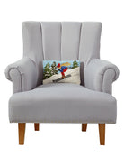 Downhill Skier Hooked Wool Christmas Throw Pillow on an armchair, showing the throw pillow at room scale, 8x12 inch