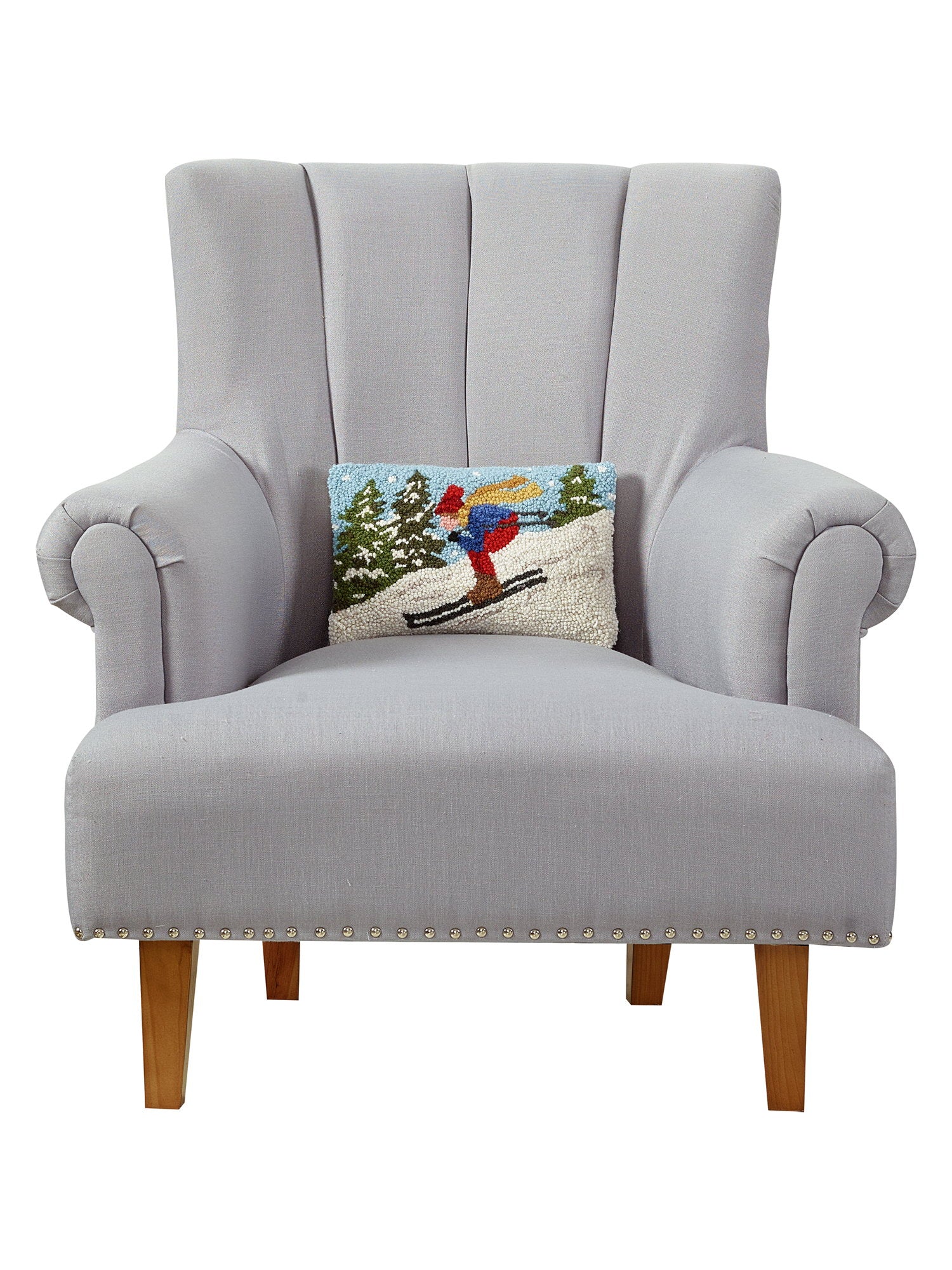 Downhill Skier Hooked Wool Christmas Throw Pillow on an armchair, showing the throw pillow at room scale, 8x12 inch