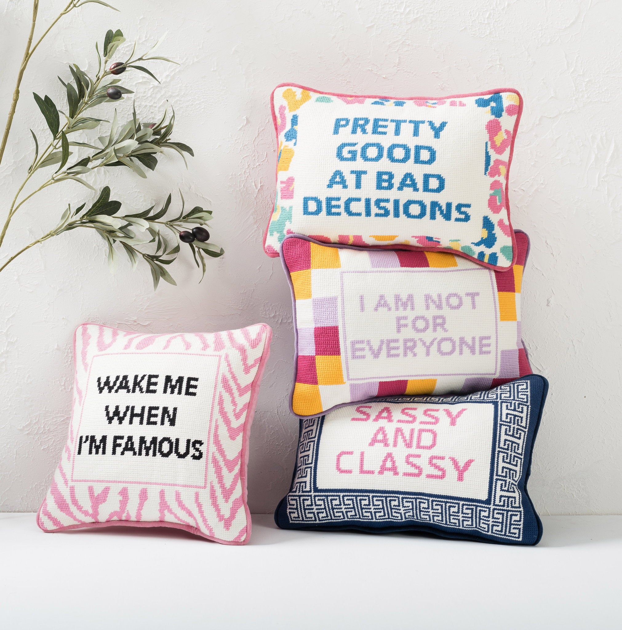 Everyone Embroidered Needlepoint Throw Pillow shown alongside other designs in the same collection, 10x14 inch