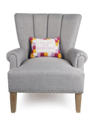 Everyone Embroidered Needlepoint Throw Pillow on an armchair, showing the throw pillow at room scale, 10x14 inch