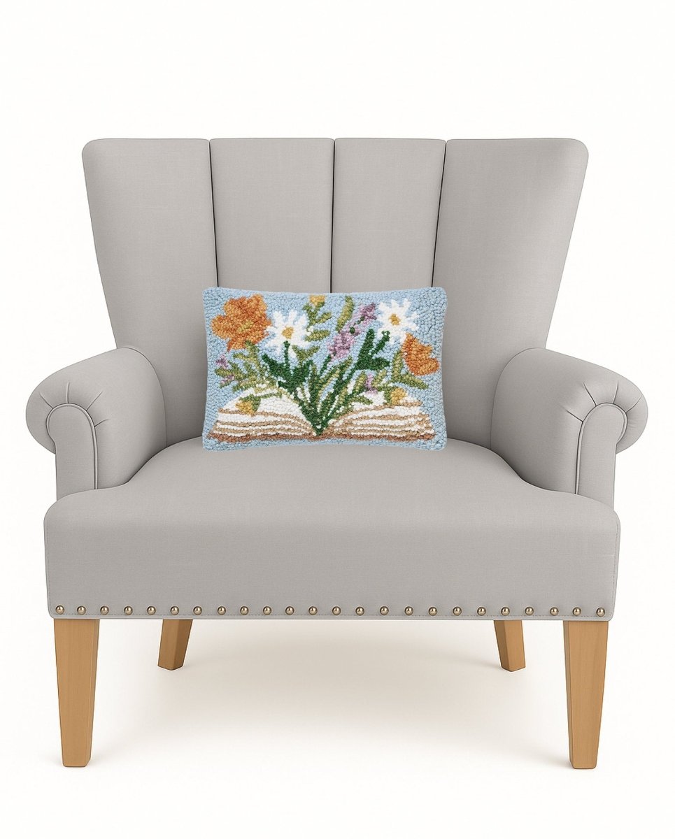 Flower Book Hooked Wool Throw Pillow on an armchair, showing the throw pillow at room scale, 8x12 inch