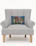 Forest Floor Mushrooms Hooked Wool Throw Pillow on an armchair, showing the throw pillow at room scale, 8x12 inch