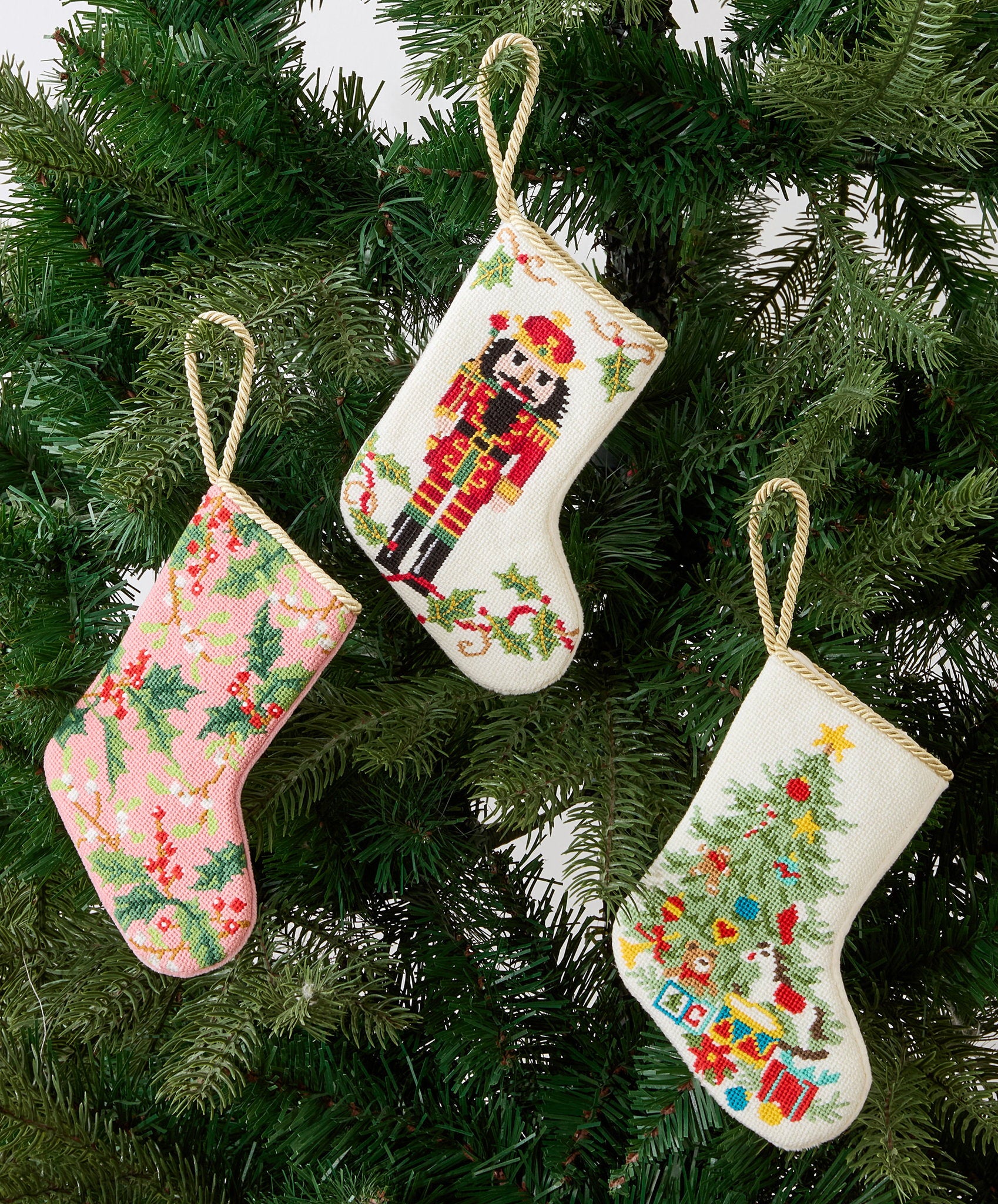 Full Figure Nutcracker Mini Embroidered Needlepoint Christmas Stocking, 6x4 inch, three stockings hanging on evergreen branches