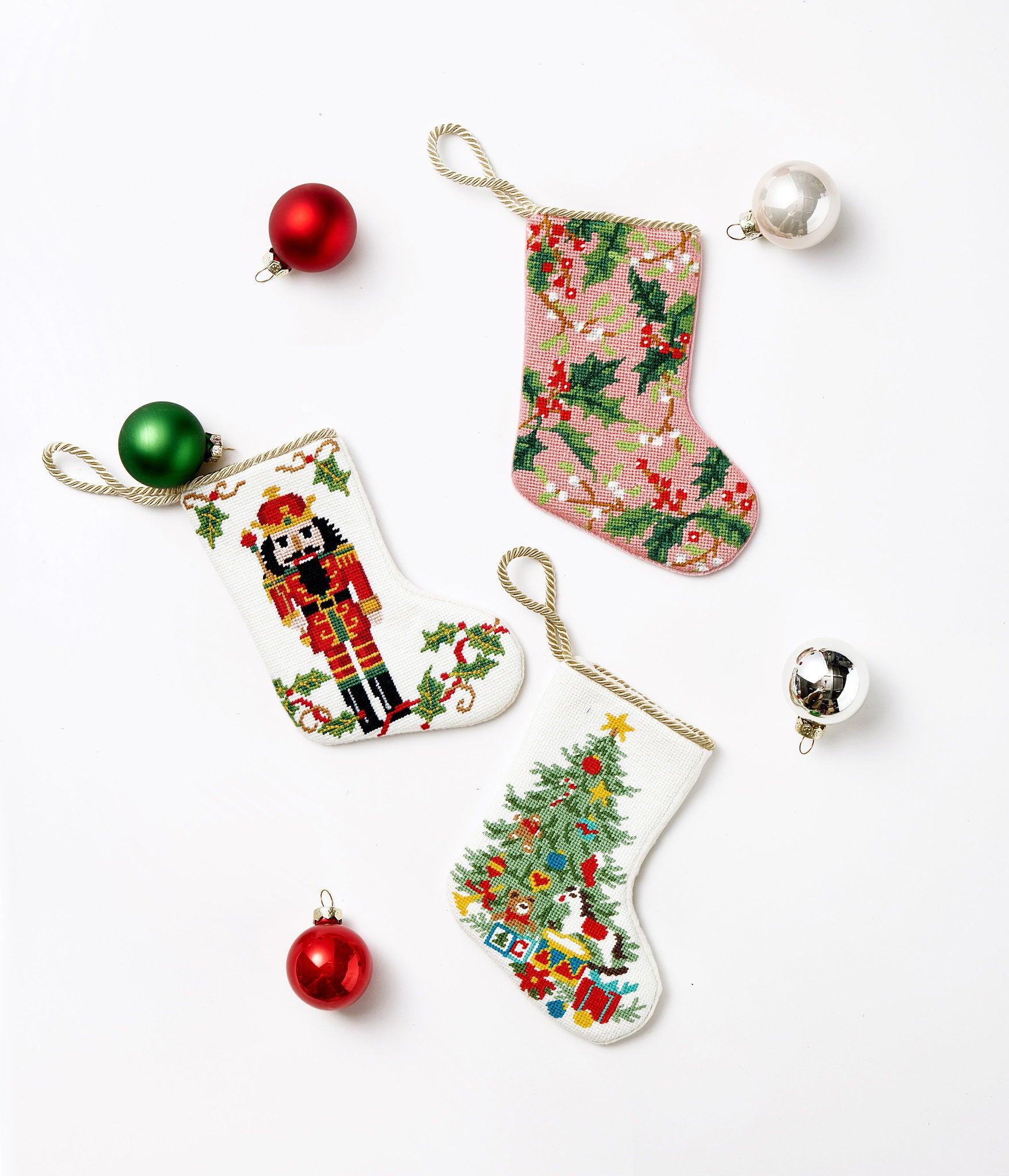Full Figure Nutcracker Mini Embroidered Needlepoint Christmas Stocking, 6x4 inch, three stockings laid flat with red and green baubles