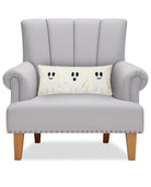 Ghost Trio on Flax Hooked Wool Halloween Throw Pillow on an armchair, showing the throw pillow at room scale, 8x20 inch