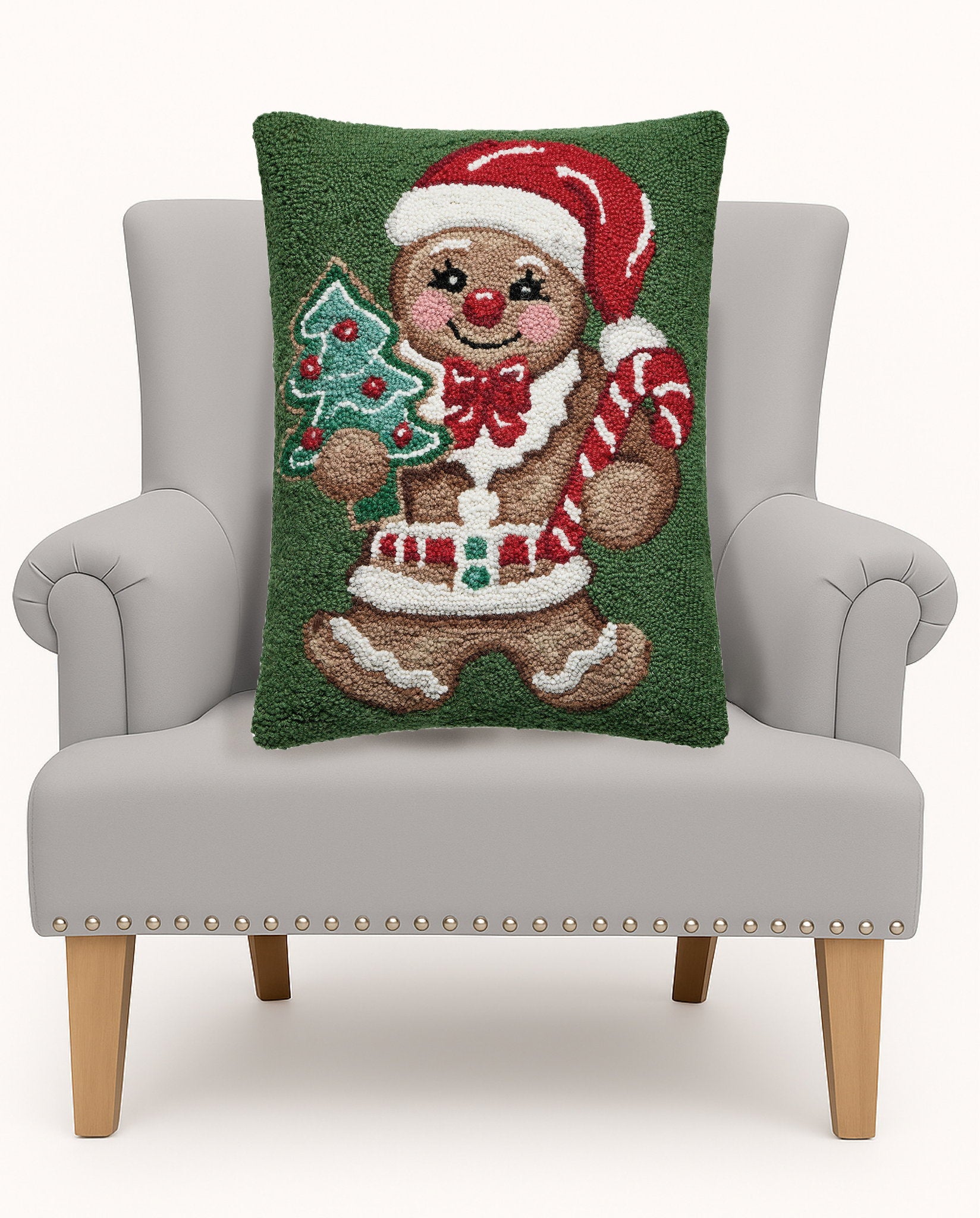Gingerbread Man Hooked Wool Christmas Throw Pillow on an armchair, showing the throw pillow at room scale, 16x20 inch