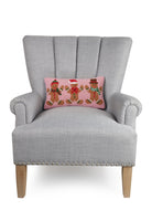 Gingerbreads Group Three Hooked Wool Christmas Throw Pillow on an armchair, showing the throw pillow at room scale, 9x16 inch