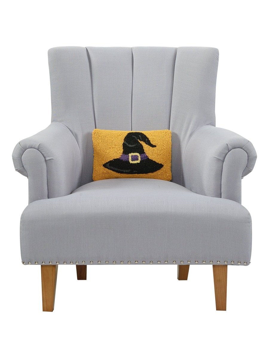 Gold Ground Witch Hat Hooked Wool Halloween Throw Pillow on an armchair, showing the throw pillow at room scale, 8x12 inch