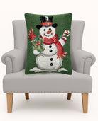 Green Ground Top Hat Snowman Hooked Wool Christmas Throw Pillow on an armchair, showing the throw pillow at room scale, 16x20 inch