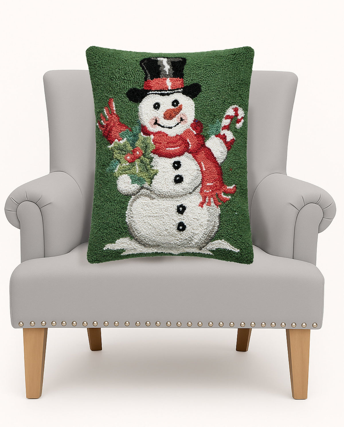 Green Ground Top Hat Snowman Hooked Wool Christmas Throw Pillow on an armchair, showing the throw pillow at room scale, 16x20 inch