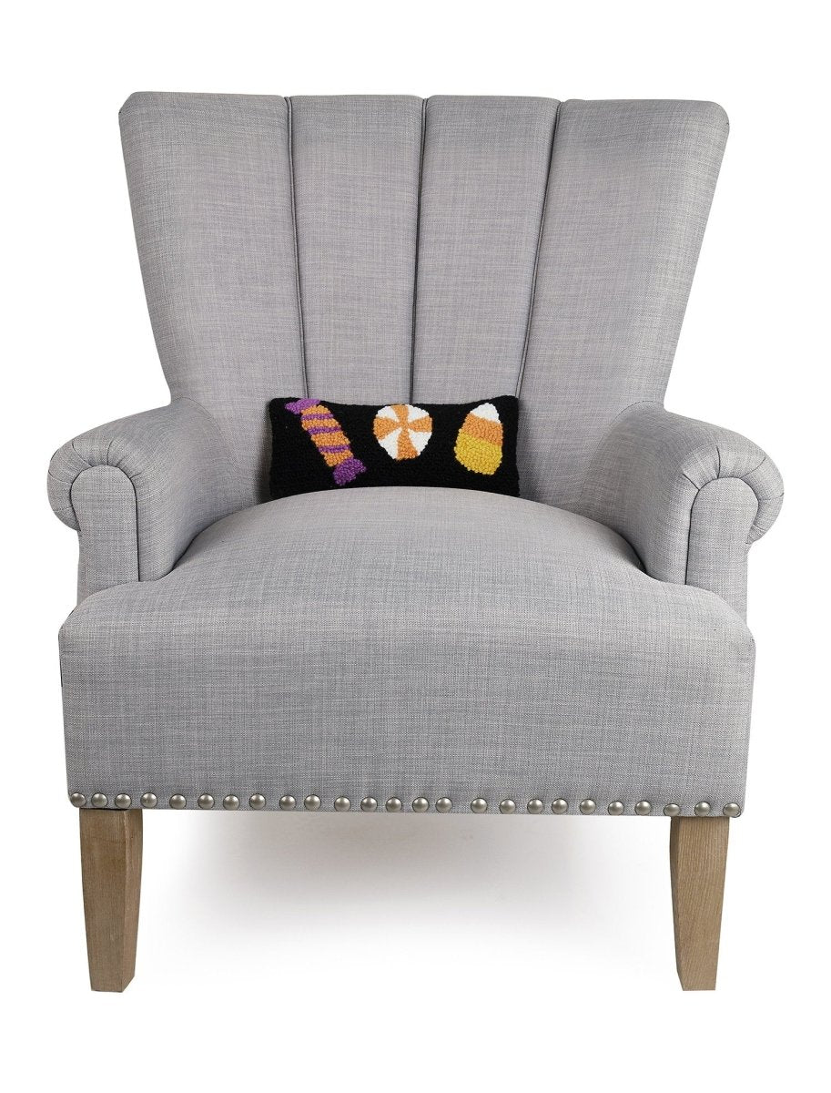Halloween Candies Trio Hooked Wool Throw Pillow on an armchair, showing the throw pillow at room scale, 12x5 inch