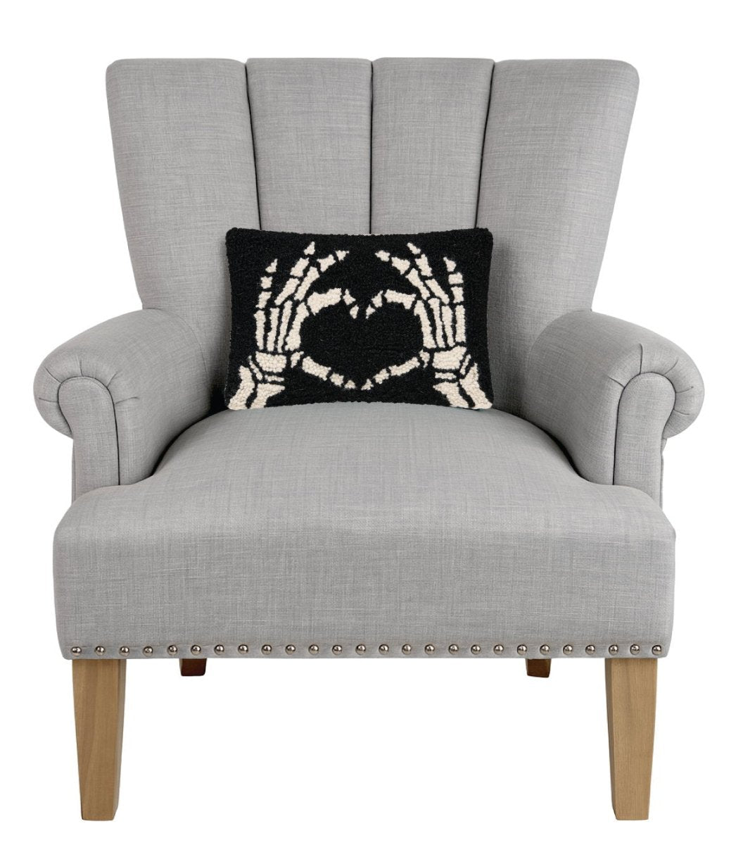 Heart Skeleton Hand Hooked Wool Halloween Throw Pillow on an armchair, showing the throw pillow at room scale, 8x12 inch