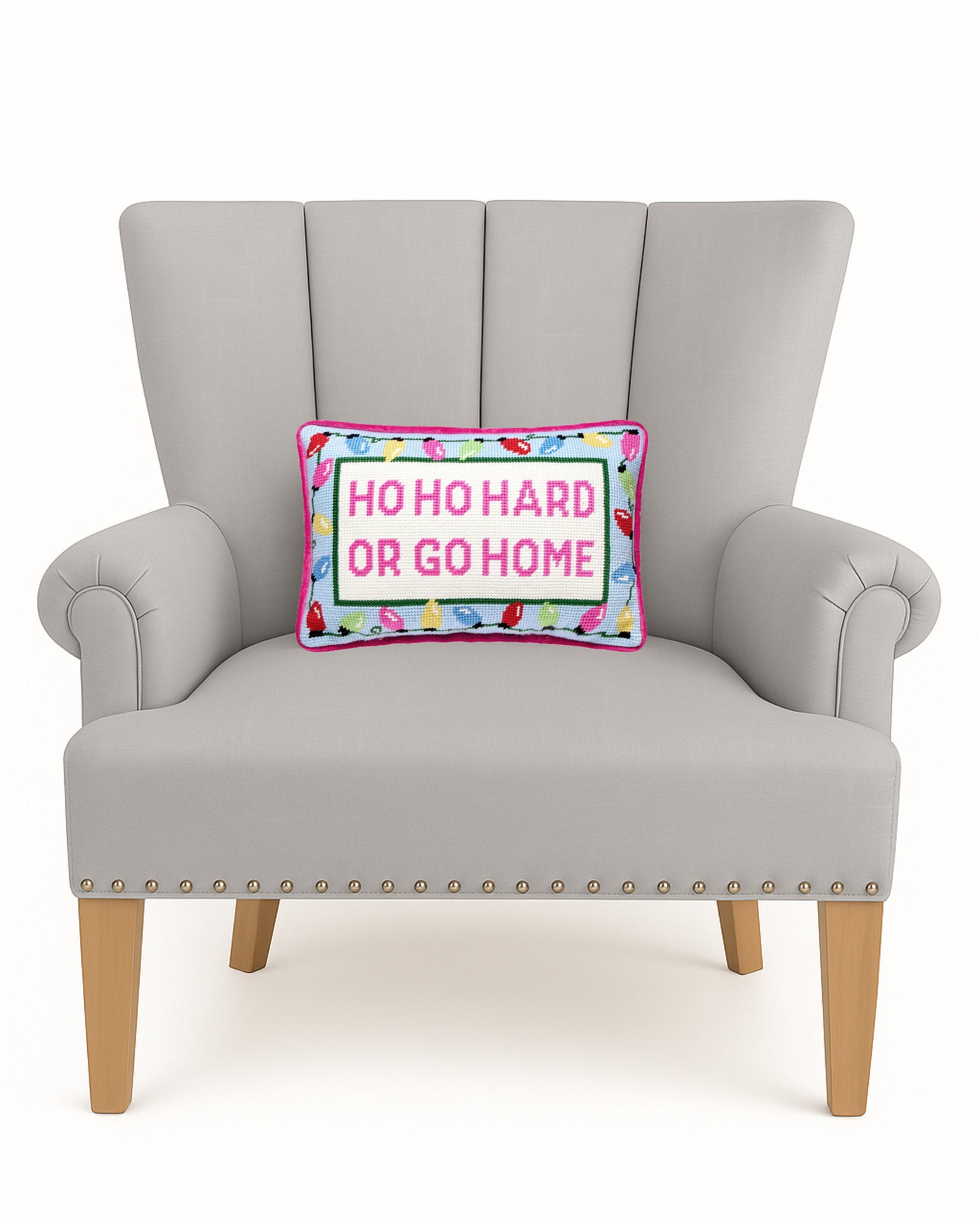 Hoho Hard Go Home Embroidered Needlepoint Christmas Throw Pillow on an armchair, showing the throw pillow at room scale, 8x12 inch