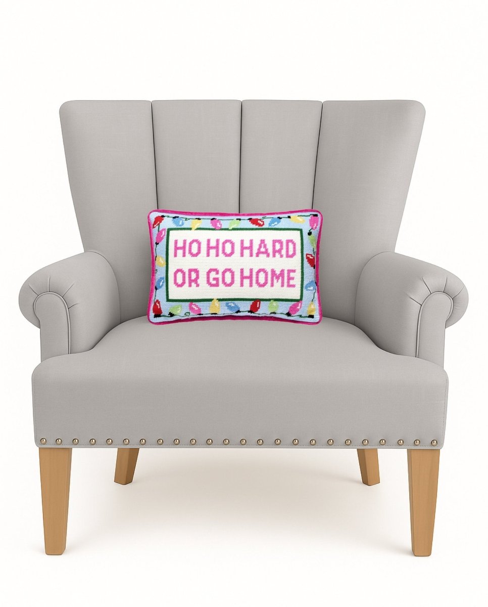 Hoho Hard Go Home Embroidered Needlepoint Christmas Throw Pillow on an armchair, showing the throw pillow at room scale, 8x12 inch
