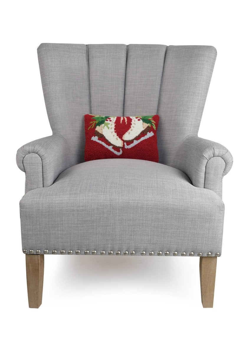 Holiday Ice Skates Hooked Wool Christmas Throw Pillow on an armchair, showing the throw pillow at room scale, 8x12 inch