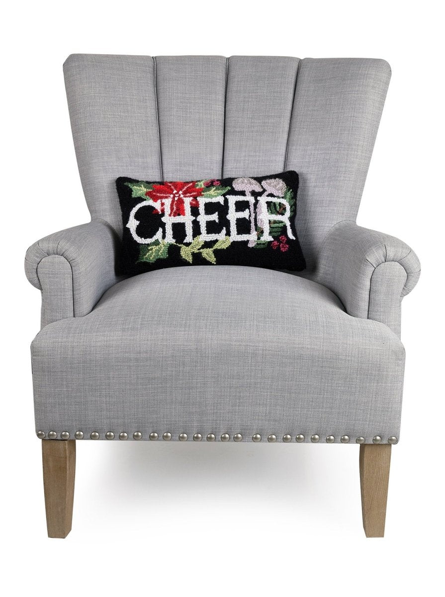 Holiday Mushrooms Cheer Hooked Wool Christmas Throw Pillow on an armchair, showing the throw pillow at room scale, 9x16 inch