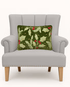 Holly Embroidered Christmas Throw Pillow on an armchair, showing the throw pillow at room scale, 12x18 inch