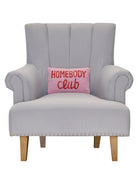 Homebody Club Hooked Wool Throw Pillow on an armchair, showing the throw pillow at room scale, 8x12 inch