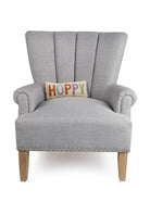 Hoppy Hooked Wool Easter Throw Pillow on an armchair, showing the throw pillow at room scale, 12x5 inch