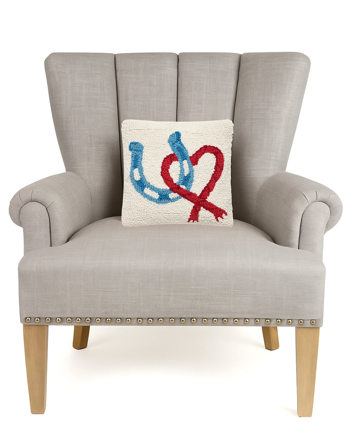 Horseshoe Heart Hooked Wool Throw Pillow on an armchair, showing the throw pillow at room scale, 10x10 inch