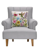 Hummingbird Wildflower Hooked Wool Throw Pillow on an armchair, showing the throw pillow at room scale, 18x18 inch