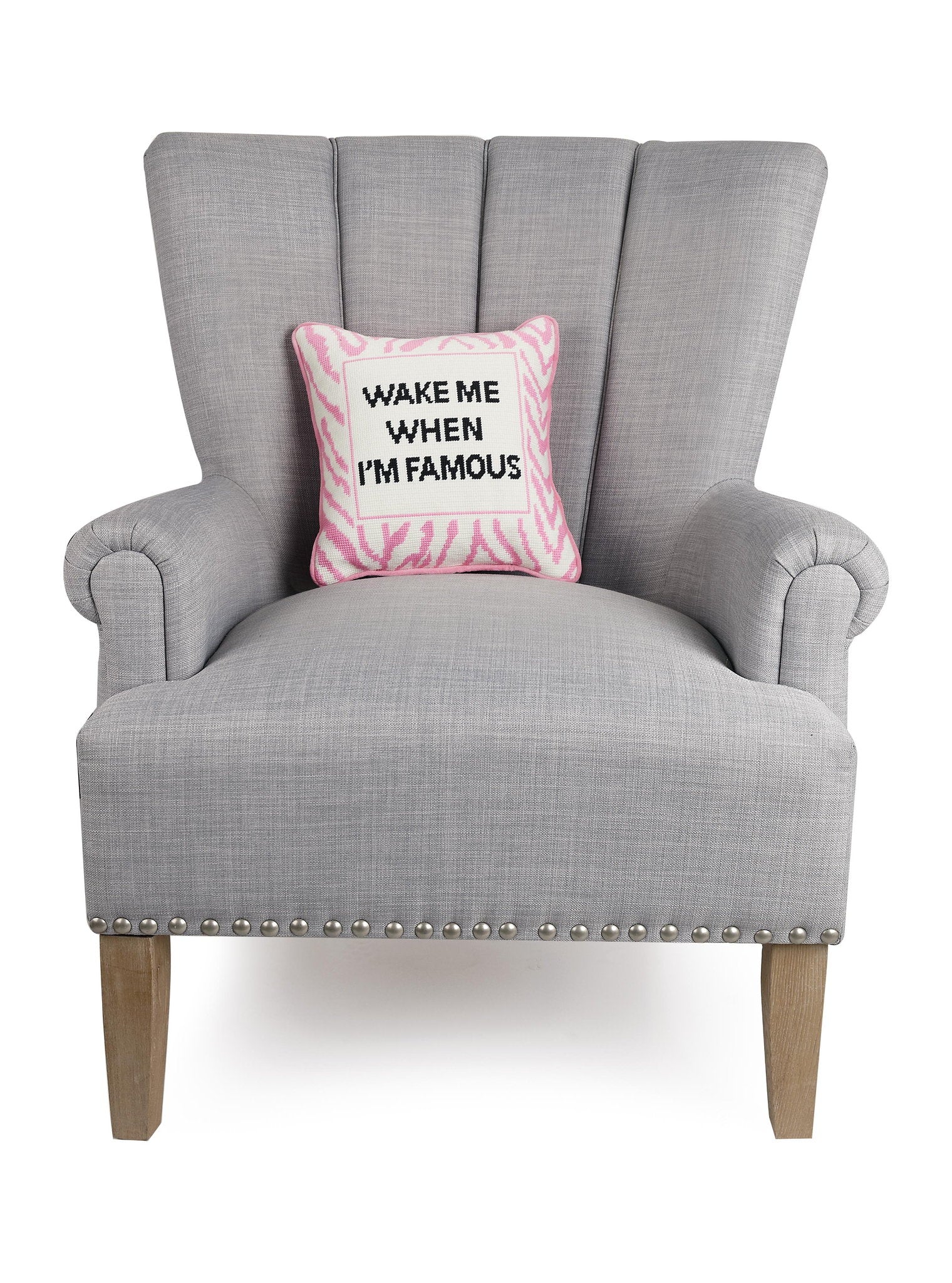 I'm Famous Embroidered Needlepoint Throw Pillow on an armchair, showing the throw pillow at room scale, 12x12 inch