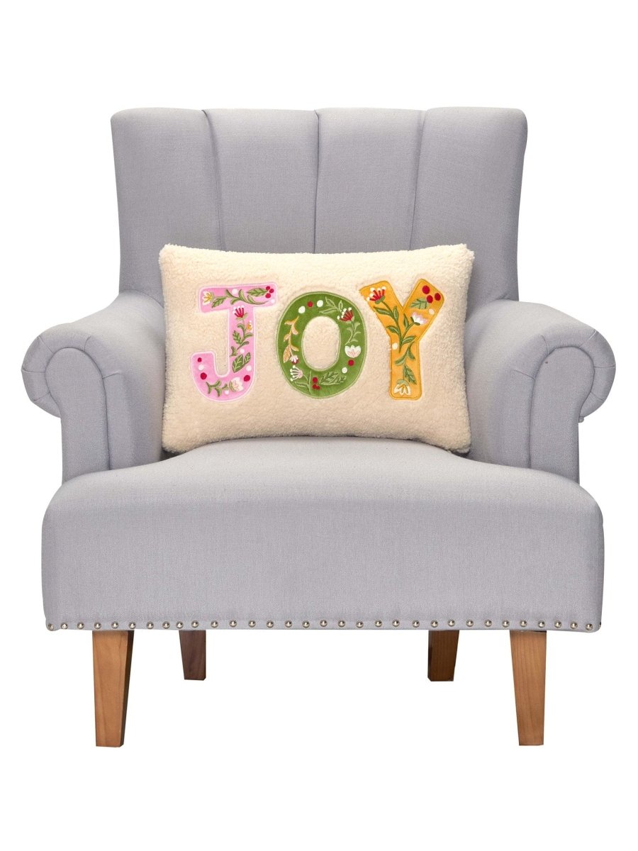 Joy Applique Embroidered Christmas Throw Pillow on an armchair, showing the throw pillow at room scale, 12x18 inch