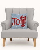 Joy Lobster Hooked Wool Christmas Throw Pillow on an armchair, showing the throw pillow at room scale, 14x14 inch