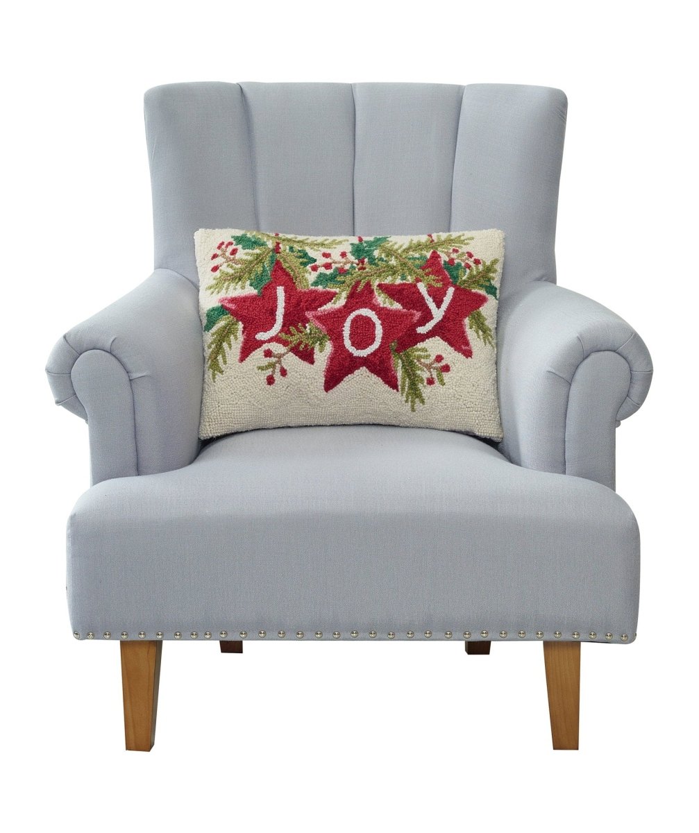 Joy Stars Hooked Wool Christmas Throw Pillow on an armchair, showing the throw pillow at room scale, 14x20 inch