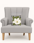 Magnolia Tufted Poly Hooked Throw Pillow on an armchair, showing the throw pillow at room scale, 10x10 inch