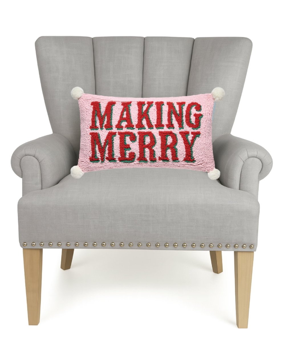 Making Merry with Pom Poms Hooked Wool Christmas Throw Pillow on an armchair, showing the throw pillow at room scale, 9x16 inch