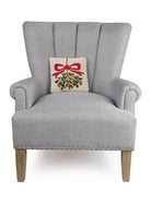 Mistletoe Hooked Wool Christmas Throw Pillow on an armchair, showing the throw pillow at room scale, 10x10 inch