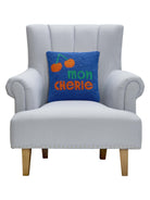 Mon Cherie Hooked Wool Throw Pillow on an armchair, showing the throw pillow at room scale, 14x14 inch