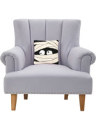 Mummy Face Hooked Wool Halloween Throw Pillow on an armchair, showing the throw pillow at room scale, 10x10 inch