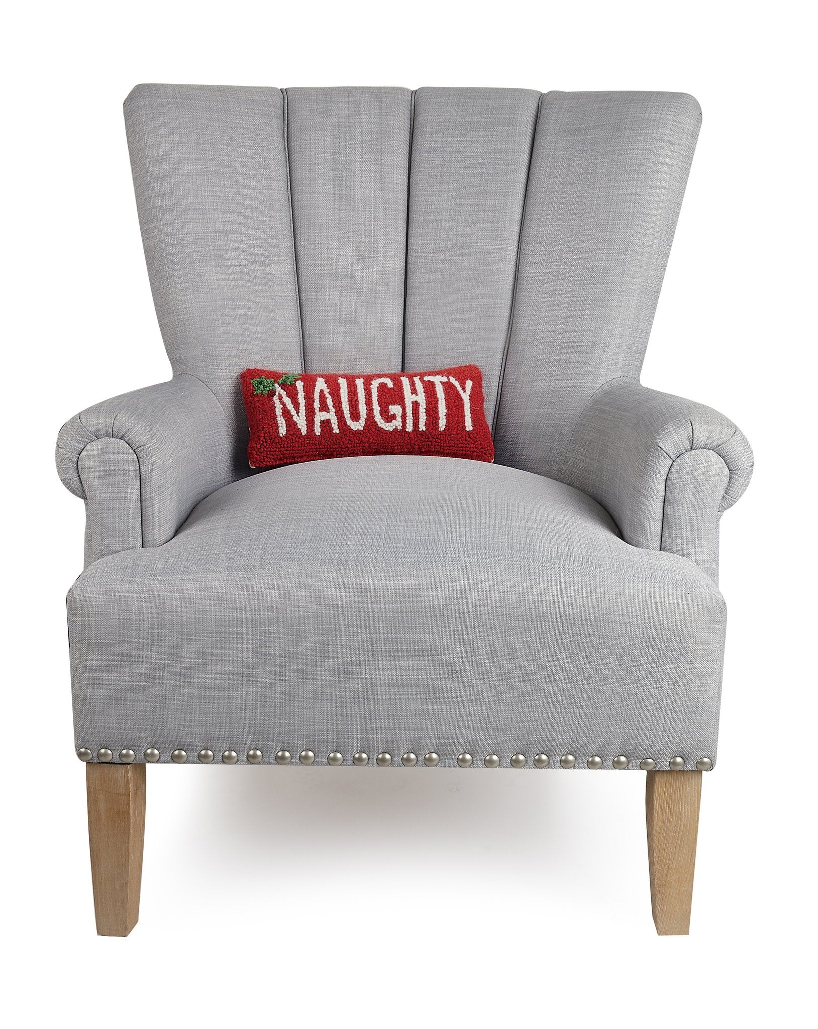 Naughty Hooked Wool Christmas Throw Pillow on an armchair, showing the throw pillow at room scale, 12x5 inch