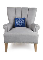 Navy Ground Sand Dollar Hooked Wool Throw Pillow on an armchair, showing the throw pillow at room scale, 10x10 inch