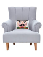 Nutcracker Face Hooked Wool Christmas Throw Pillow on an armchair, showing the throw pillow at room scale, 8x12 inch