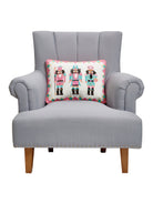 Nutcrackers Embroidered Needlepoint Christmas Throw Pillow on an armchair, showing the throw pillow at room scale, 14x18 inch