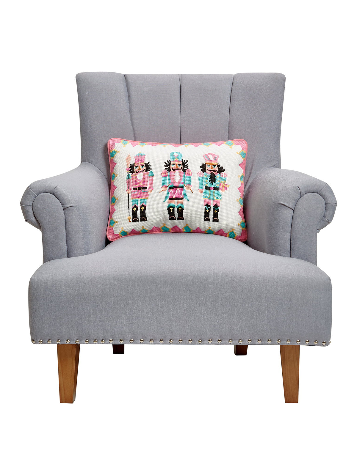 Nutcrackers Embroidered Needlepoint Christmas Throw Pillow on an armchair, showing the throw pillow at room scale, 14x18 inch
