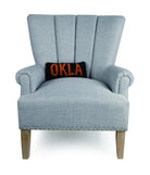Oklahoma Black/Orange Hooked Wool Throw Pillow on an armchair, showing the throw pillow at room scale, 12x5 inch