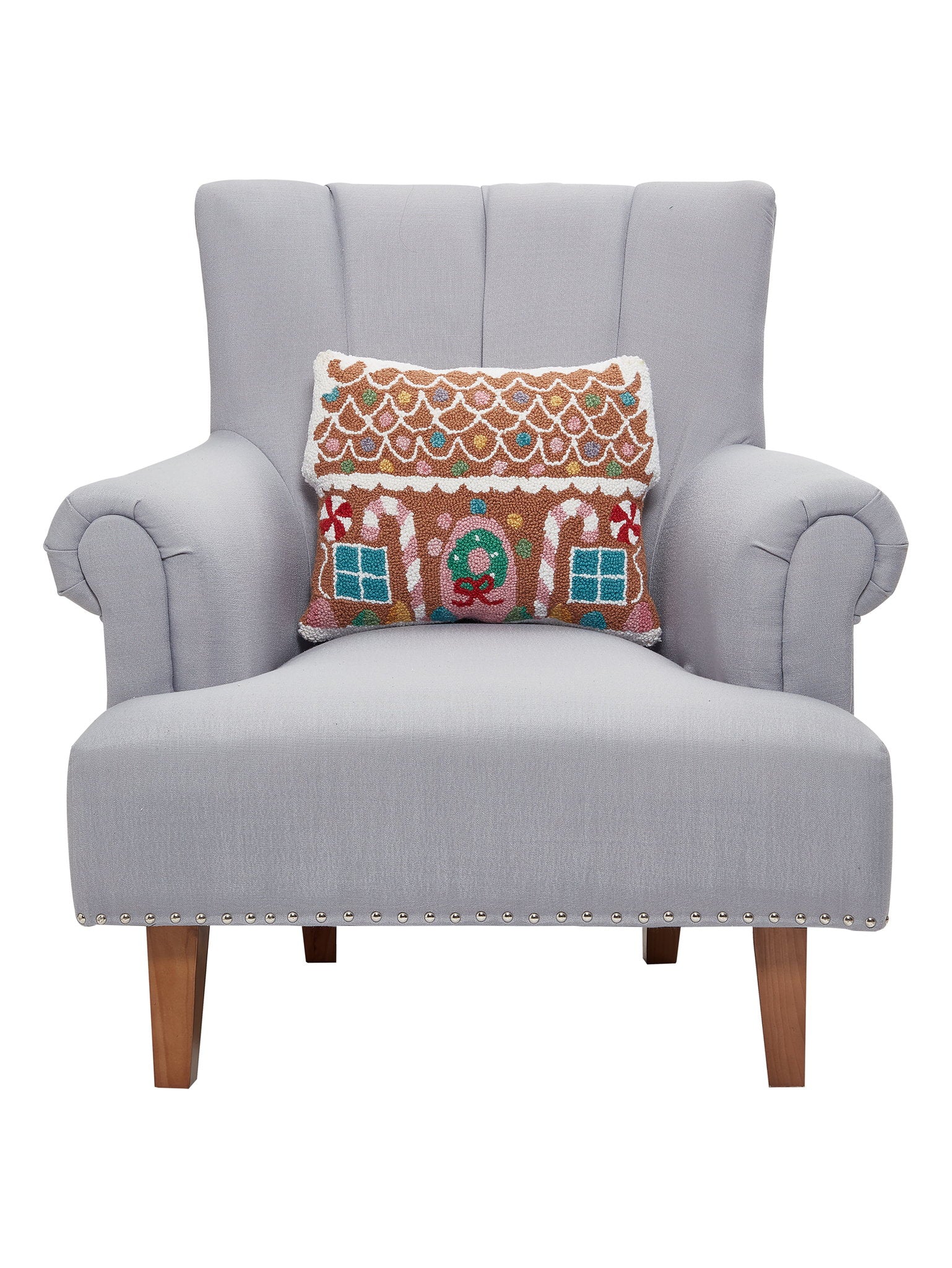 Pastel Gingerbread House Hooked Wool Christmas Throw Pillow on an armchair, showing the throw pillow at room scale, 14x18 inch