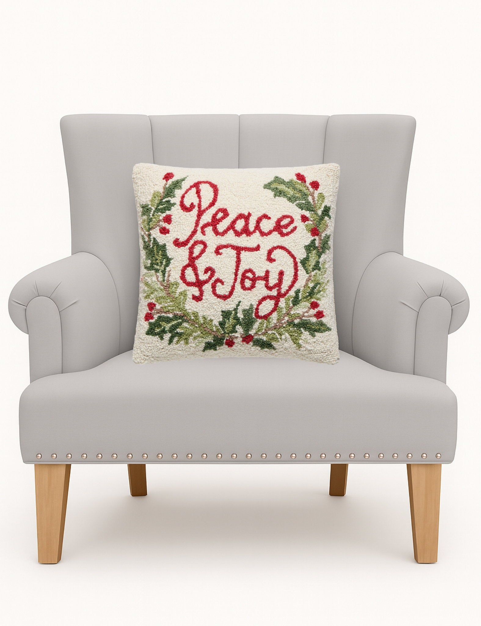 Peace & Joy Hooked Wool Christmas Throw Pillow on an armchair, showing the throw pillow at room scale, 16x16 inch