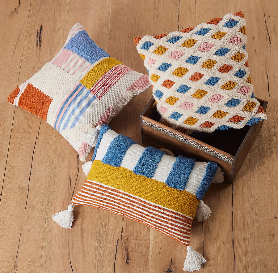 Percy Decorative Hooked Throw Pillow, 12x18 inch, four pillows around a wooden box on a plank floor