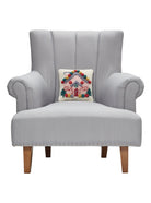 Pink House Hooked Wool Christmas Throw Pillow on an armchair, showing the throw pillow at room scale, 10x10 inch