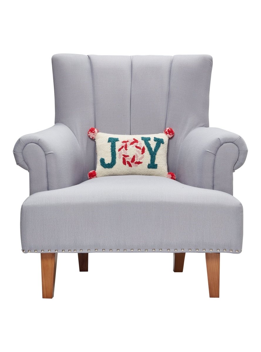 Pink Joy with Pompom Hooked Wool Christmas Throw Pillow on an armchair, showing the throw pillow at room scale, 8x12 inch