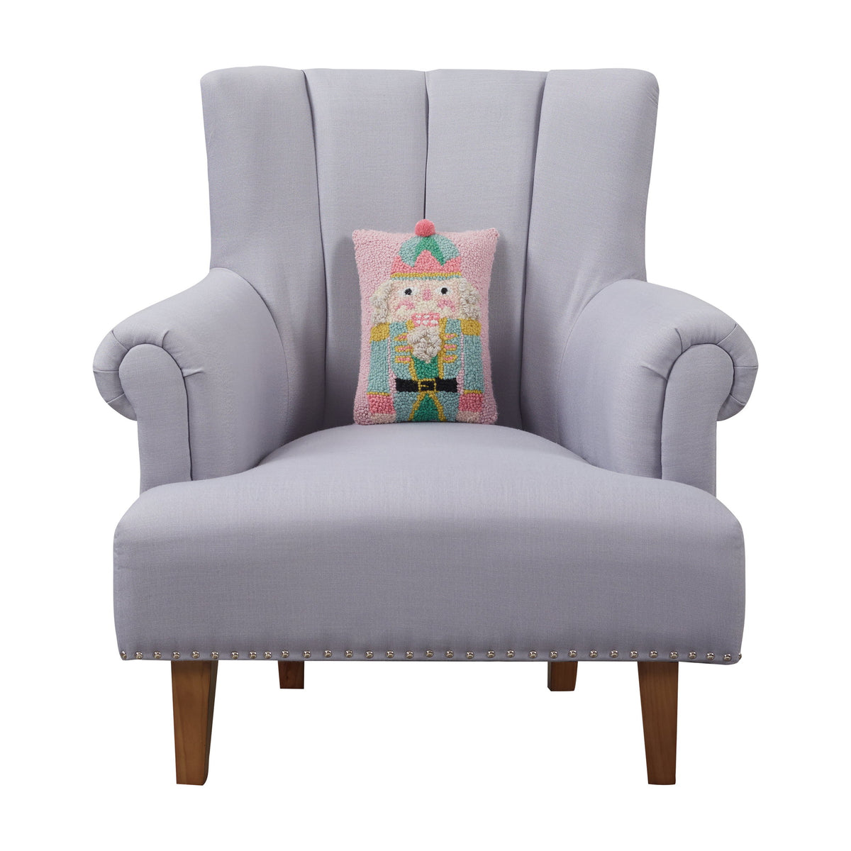 Pink Nutcracker Hooked Wool Christmas Throw Pillow on an armchair, showing the throw pillow at room scale, 8x12 inch