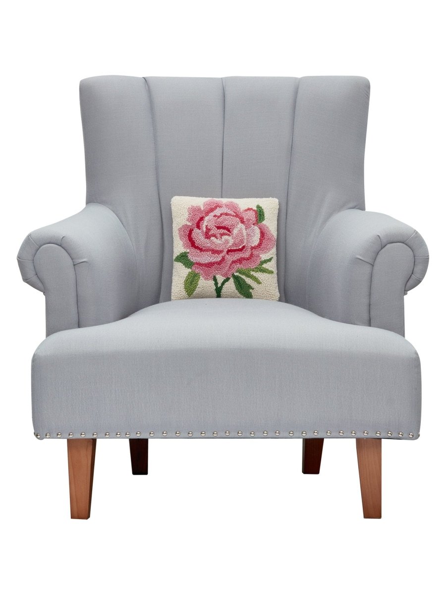 Pink Peony Hooked Wool Throw Pillow on an armchair, showing the throw pillow at room scale, 10x10 inch