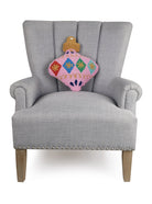 Pink Shaped Hooked Wool Christmas Throw Pillow on an armchair, showing the throw pillow at room scale, 14x18 inch